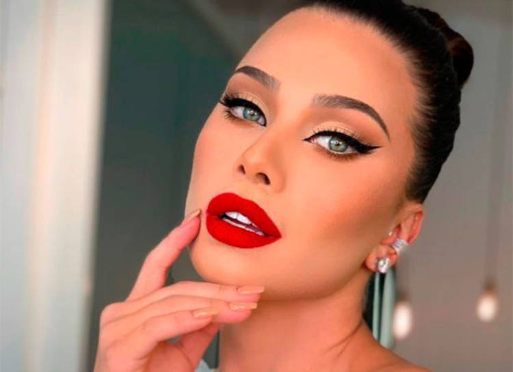 Flavia Pavanelli usando delineado gatinho preto e batom vermelho
