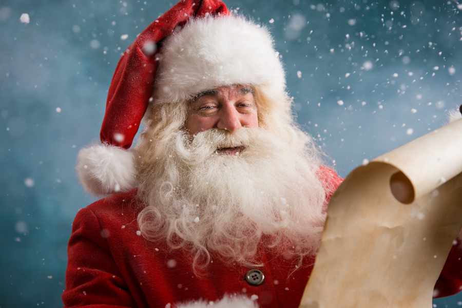 Foto de Papai Noel na neve lendo carta.