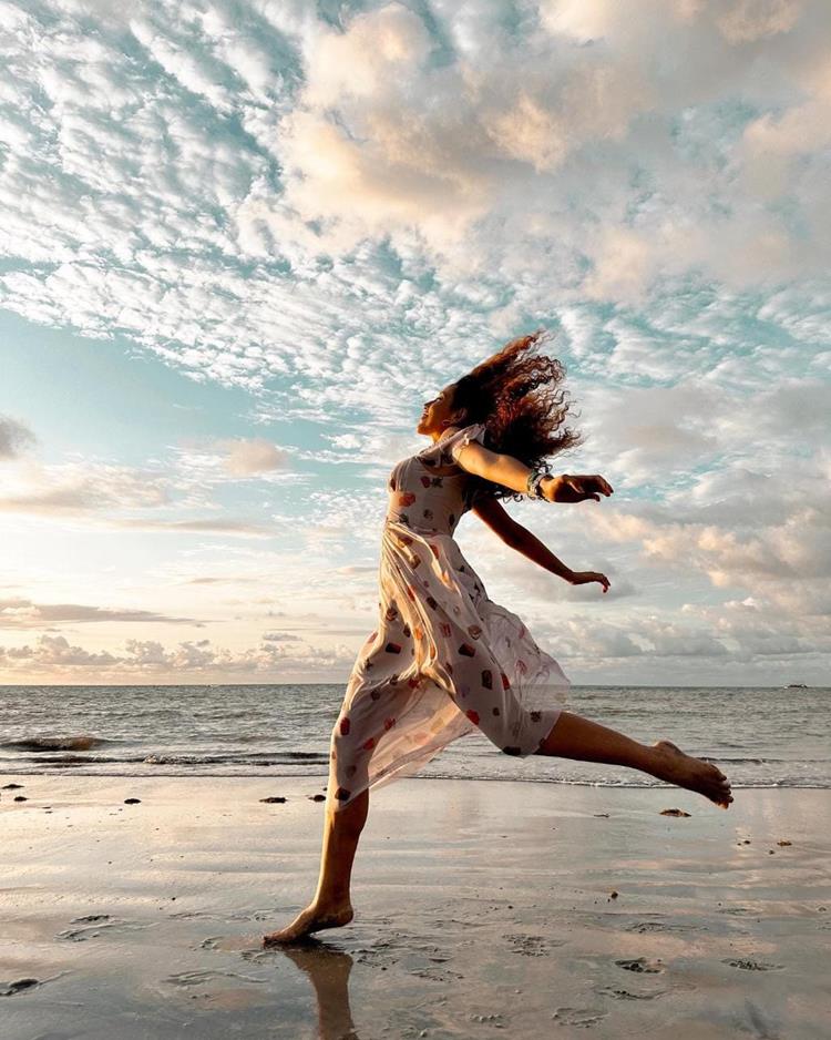 foto de mulher pulando na praia
