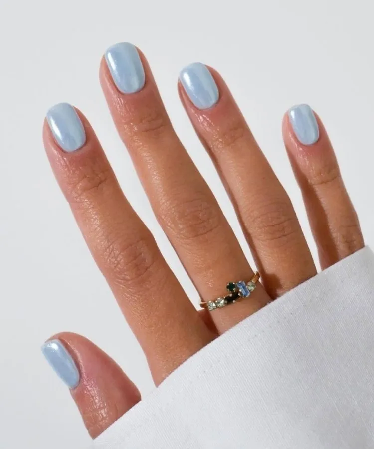 Foto de unhas pintadas com esmalte azul-claro, uma das tendências de unhas para 2026