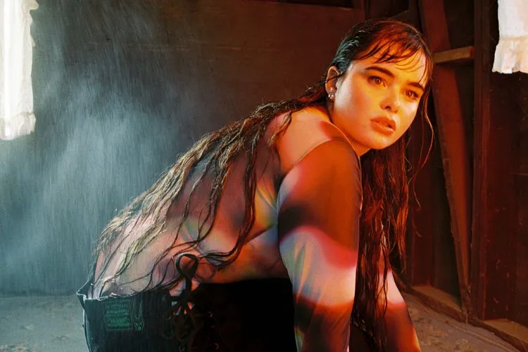 Barbie Ferreira em uma posição agachada com um a blusa de tule estampada