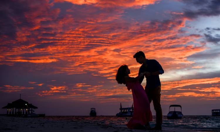 Casal no pôr do sol na praia.