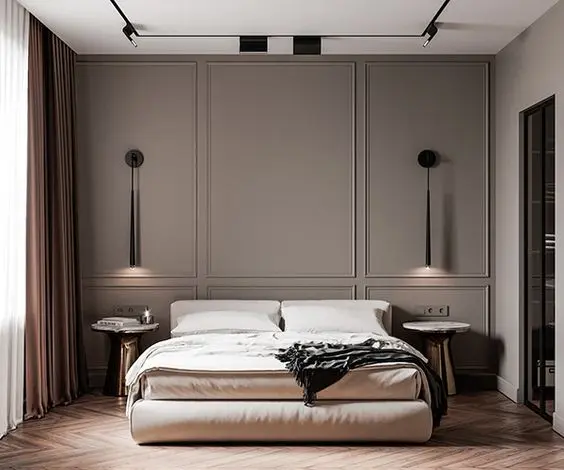 Quarto de casal com parede marrom com moldura, luminárias suspensas, cama e mesas de cabeceira 