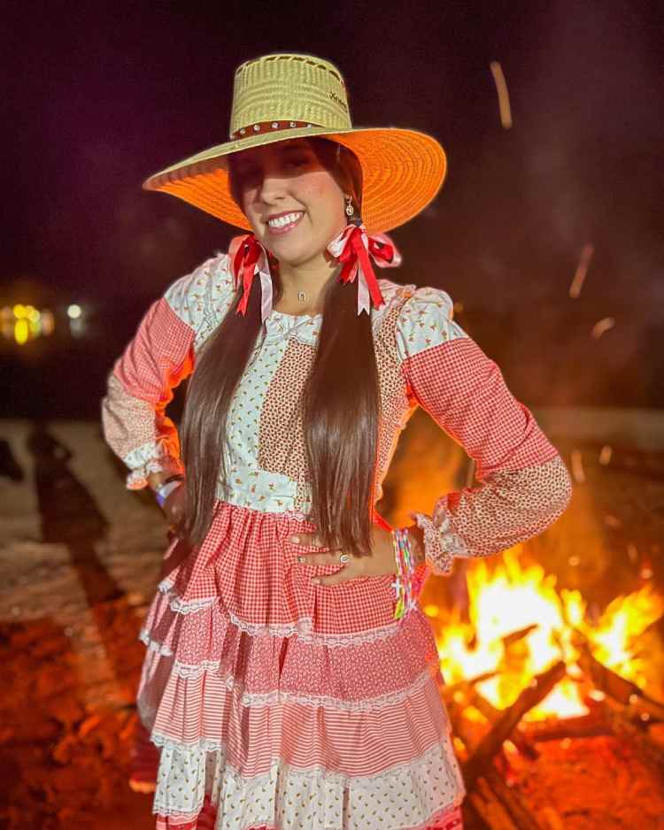 mulher com vestido de festa junina branco e vermelho