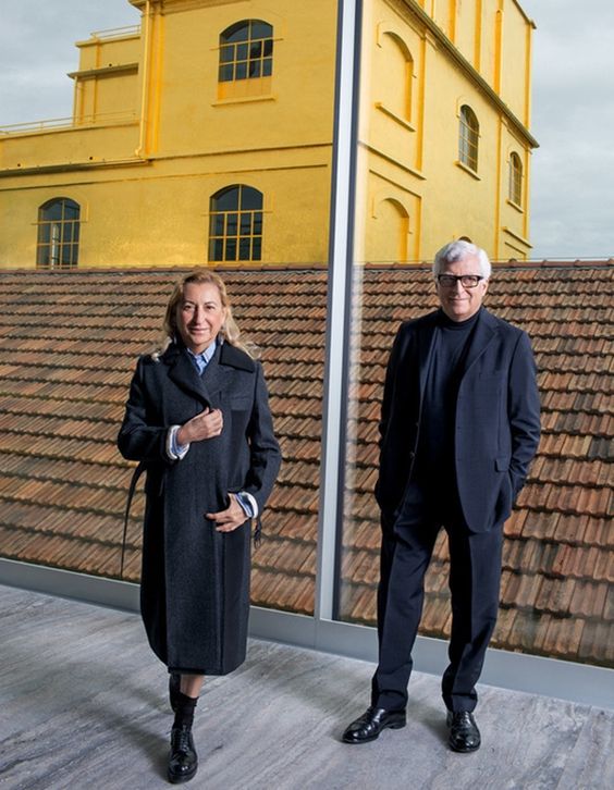 Miuccia Prada, Patrizio Bertelli, Fundação Prada, Milão, moda e arte Foto de Miuccia Prada e Patrizio Bertelli perto de uma janela de vidro transparente com fundo de telhado e edifício dourado