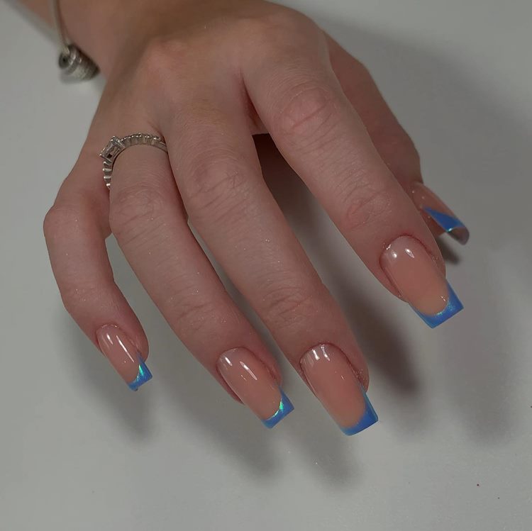 Unhas decoradas em tons de azul com francesinha perolado