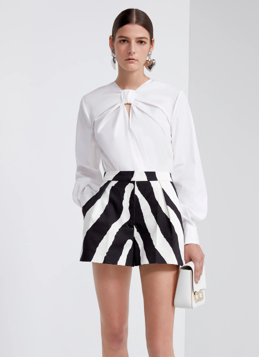 Blusa com decote nó e short de zebra.