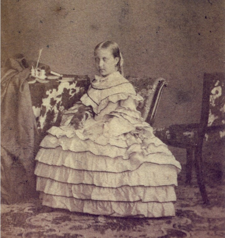 Foto em preto e branco da Princesa Isabel do Brasil criança, posando com um vestido com babados Foto de Isabel, Princesa imperial do Brasil, posando com um vestido com babados aos 12 anos, em 1858.