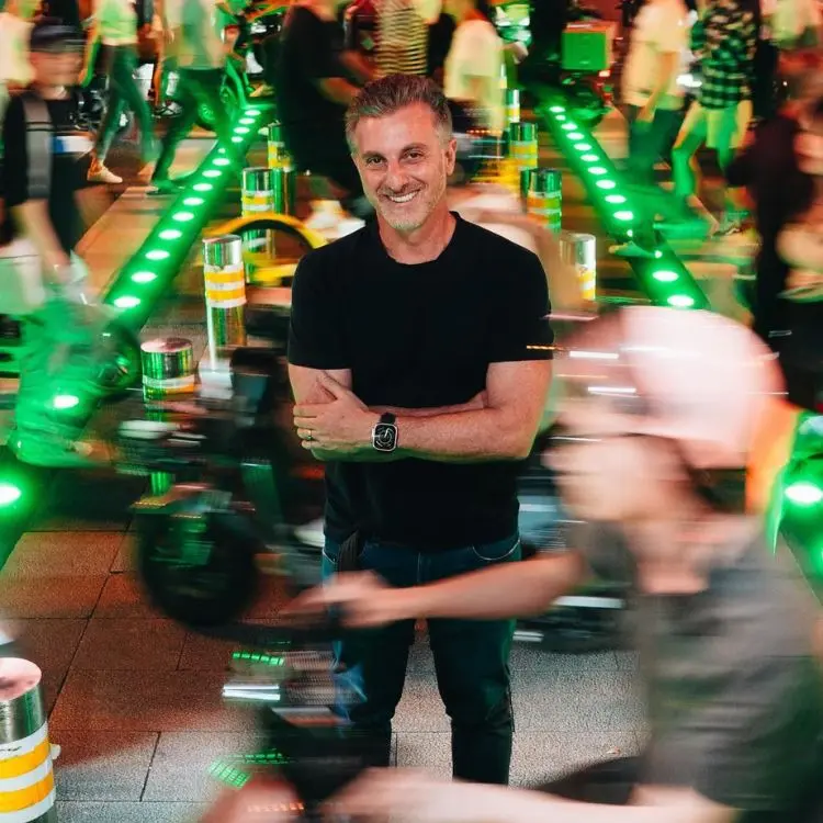 Luciano Huck de look preto em rua movimentada na China