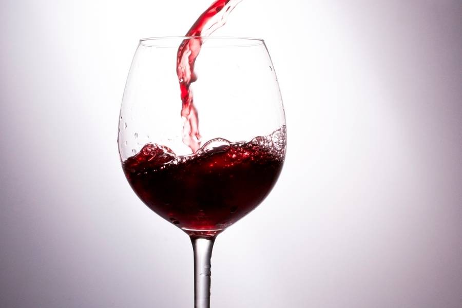 Taça sendo servida com vinho. 