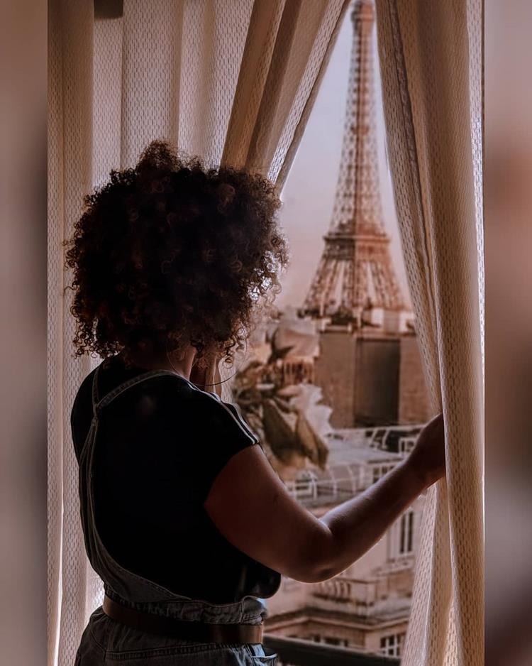 foto de mulher olhando para paisagem de paris na janela