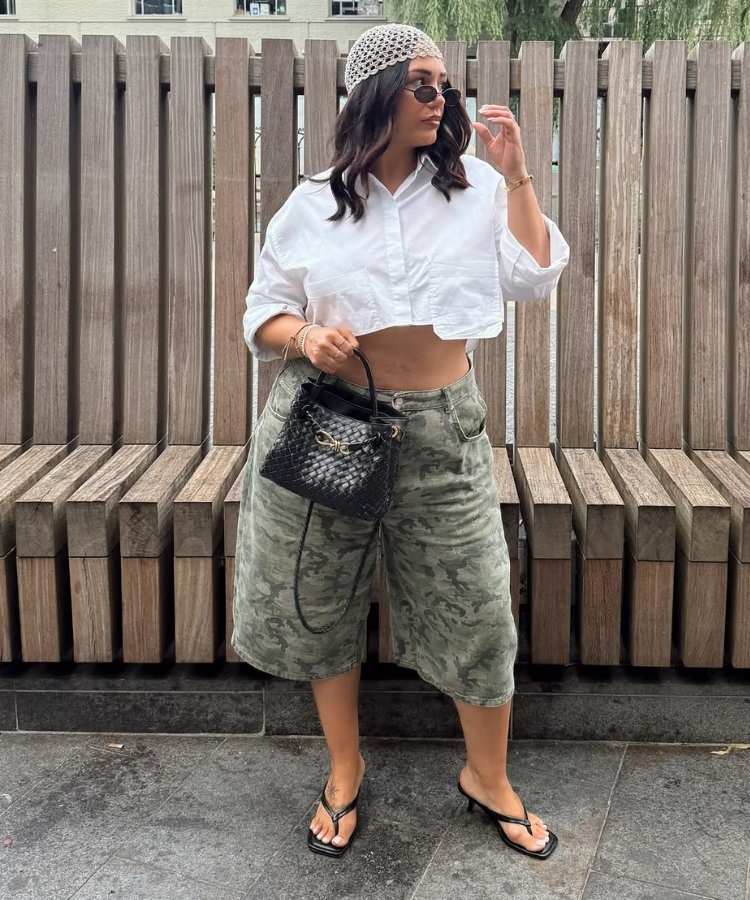 Mulher usando camisa branca cropped e bermuda com estampa camuflada