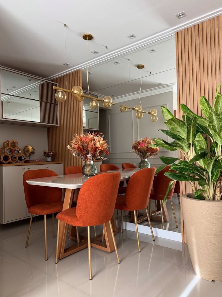 Sala de jantar em laranja queimado com luminárias suspensas modernas 