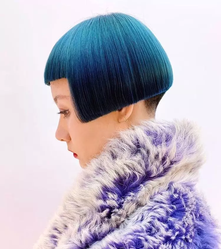 Mulher com corte de cabelo curto azul Box Bob, usando casaco peludo
