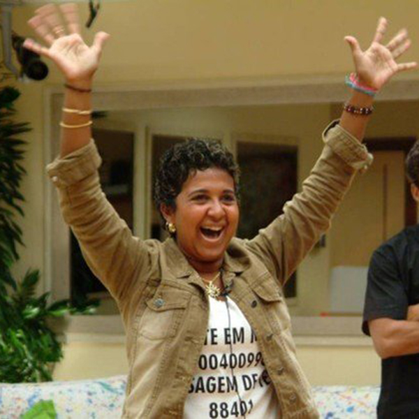 Foto de Cida no BBB usando blusa branca e jaqueta marrom