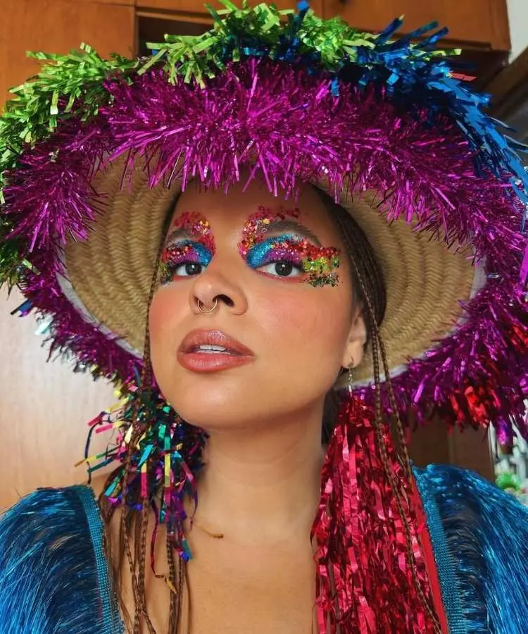 Foto de mulher usando chapéu de palha com franjas coloridas, uma das tendências de Carnaval 2026
