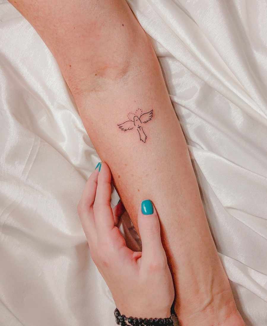 Foto de tattoo do Divino Espírito Santo no braço de uma pessoa.