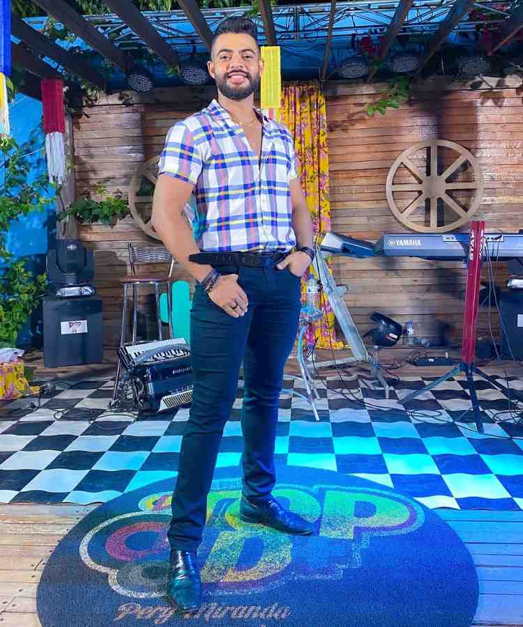 Homem em festa junina usando camisa xadrez, calça jeans e sapato social