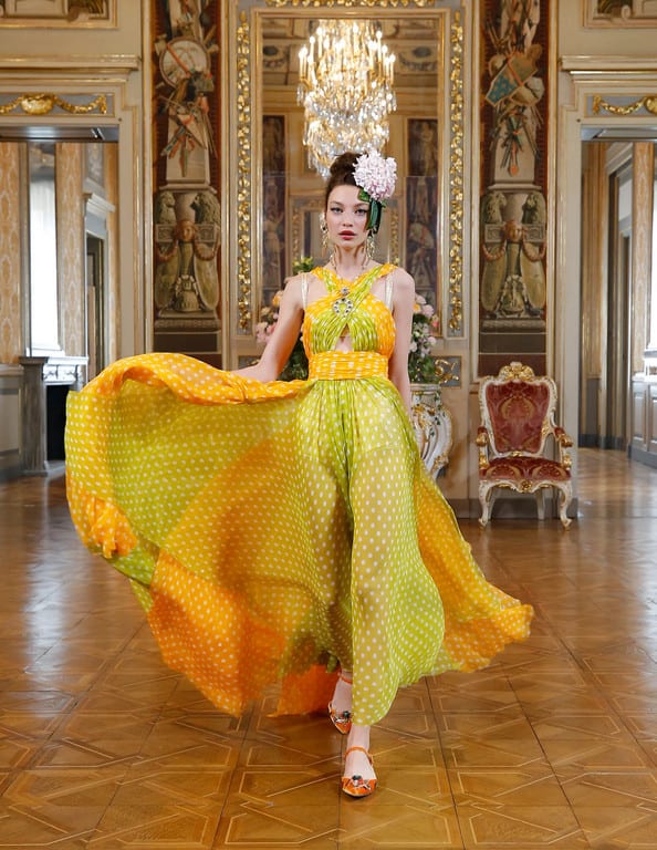 Modelo com vestido esvoaçante e acinturado com estampa de bolinhas - poá verde claro e laranja - D&G Modelo com vestido esvoaçante e acinturado