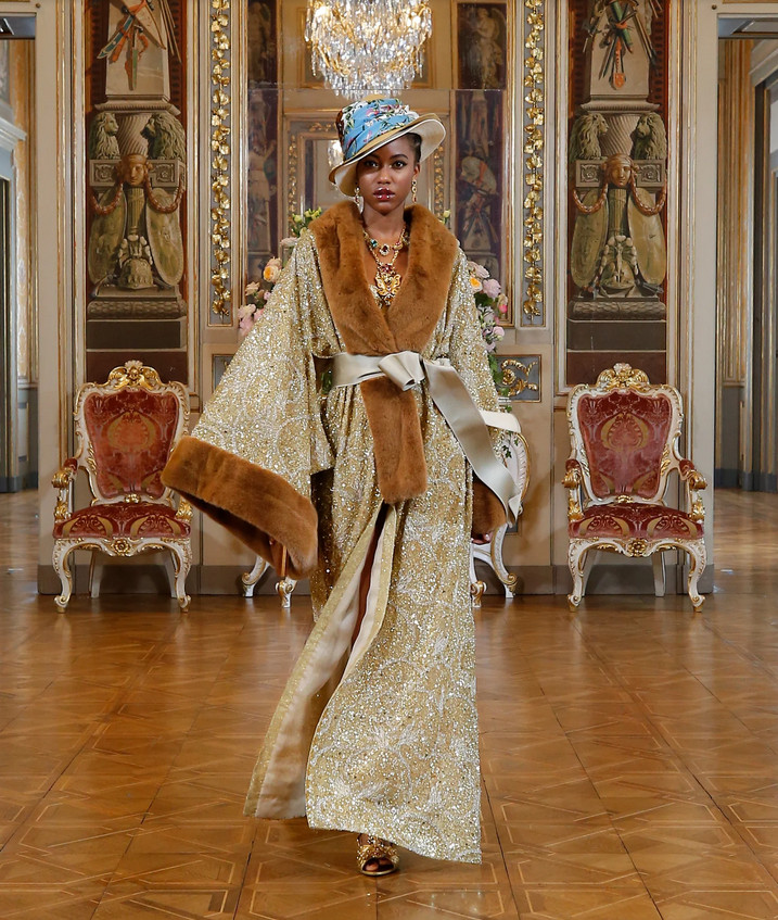 Modelo negra usando kimono dourado com peles na gola e na mangas e chapeu anos 20 - D&G Modelo negra usando kimono dourado com peles na gola e na mangas e chapeu anos 20 - D&G