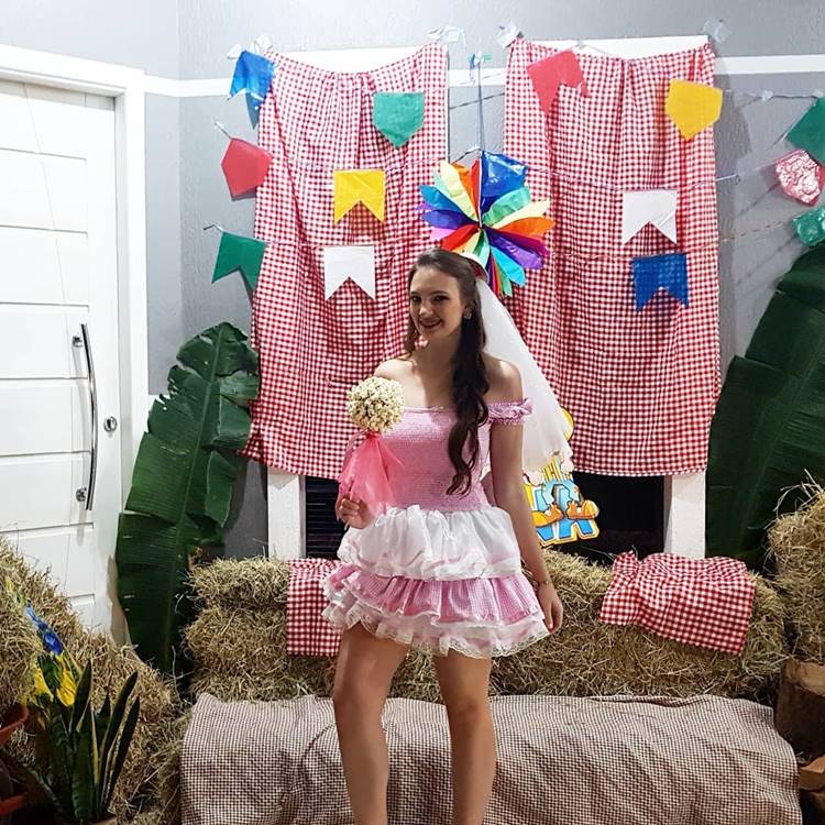 Noiva caipira ocm buquê de pipoca em painel decorativo de festa junina