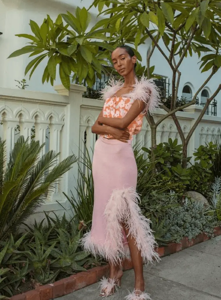 Mulher usando roupas com detalhes em penas.