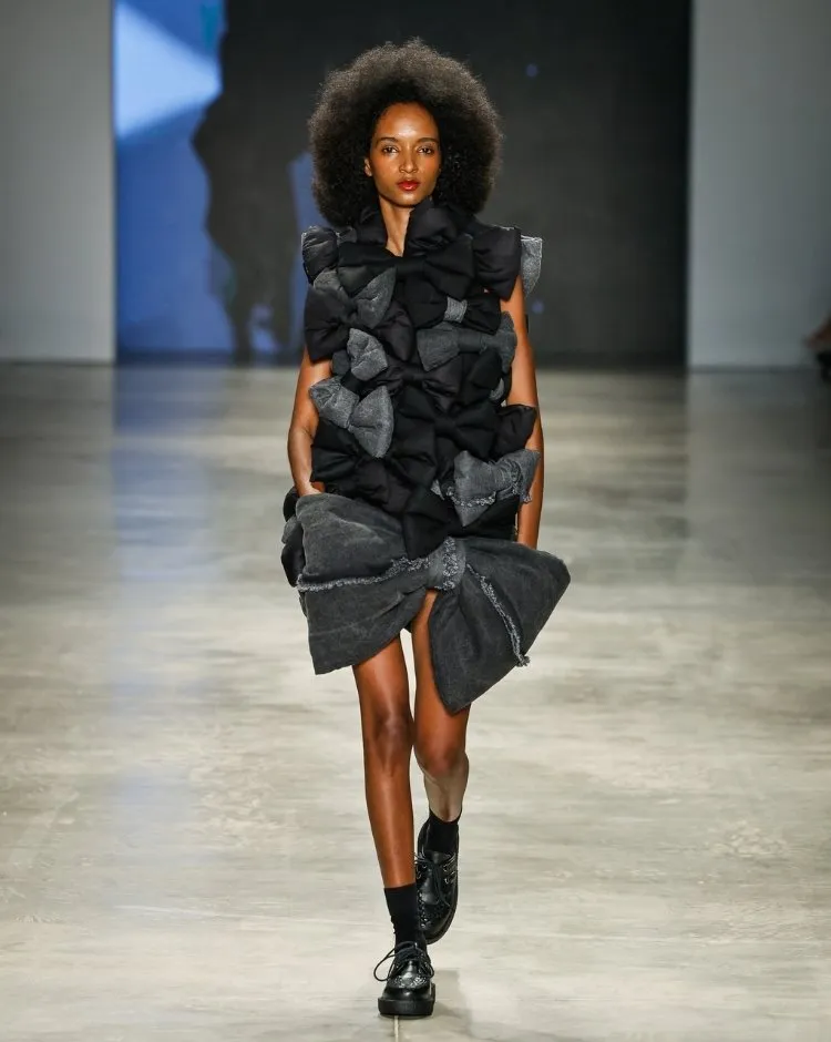 Foto de modelo usando vestido preto com laços no desfile de Sou de Algodão durante o SPFW N60