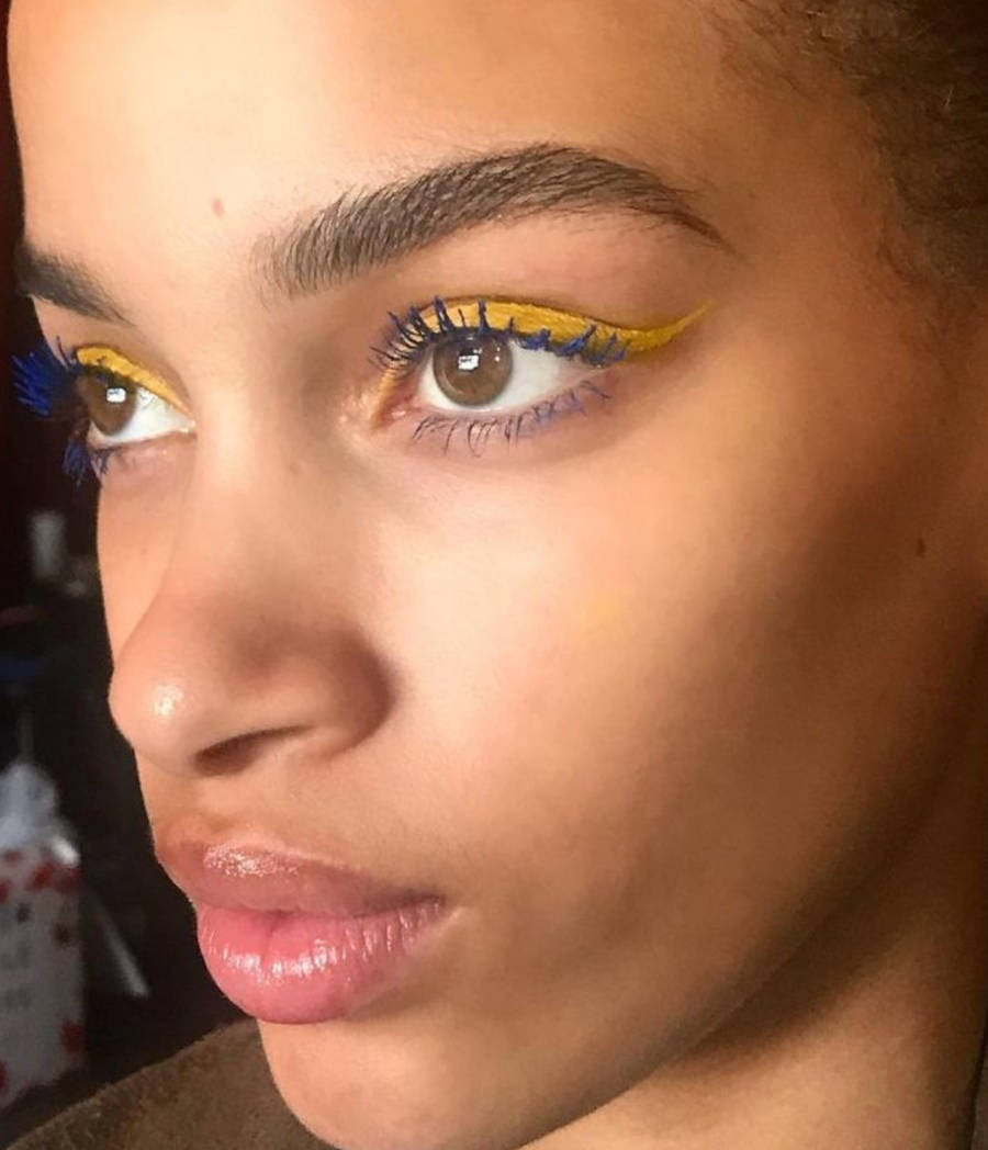 Foto de modelo com sombra amarela e rímel azul para a copa