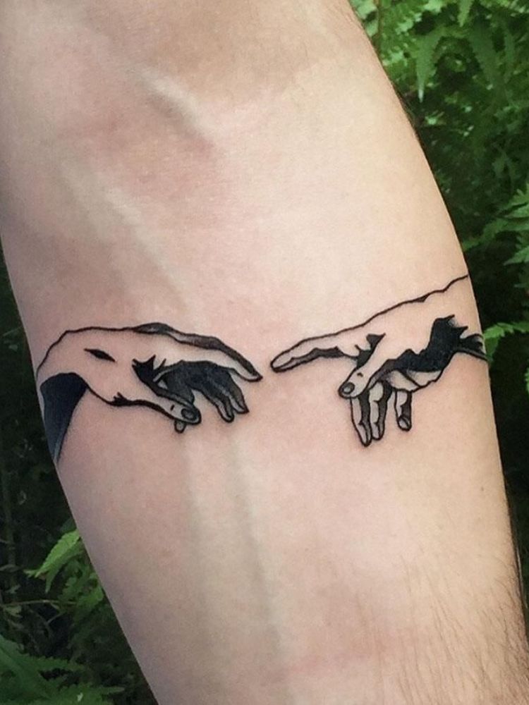 Tatuagem inspirada na obra "criação de adão". 