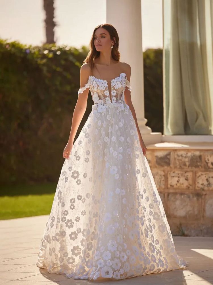 Mulher de pele clara usando vestido de noiva com saia e corselet bordados com flores