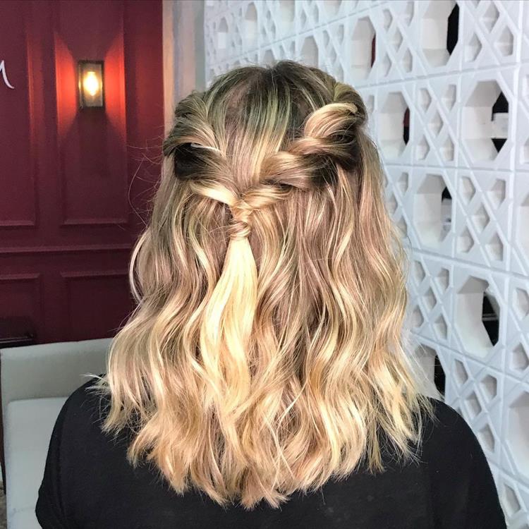mulher com cabelo curto meio preso com tranças laterais amarradas atrás 