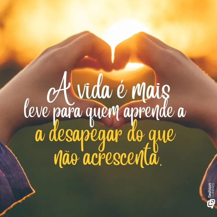 Duas mãos formam um coração contra o sol poente, criando uma silhueta bonita e cheia de simbolismo. A imagem ilustra uma mensagem sobre a leveza de desapegar do que não acrescenta.