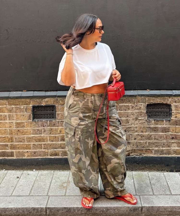 Mulher usando camiseta branca cropped e calça com estampa camuflada