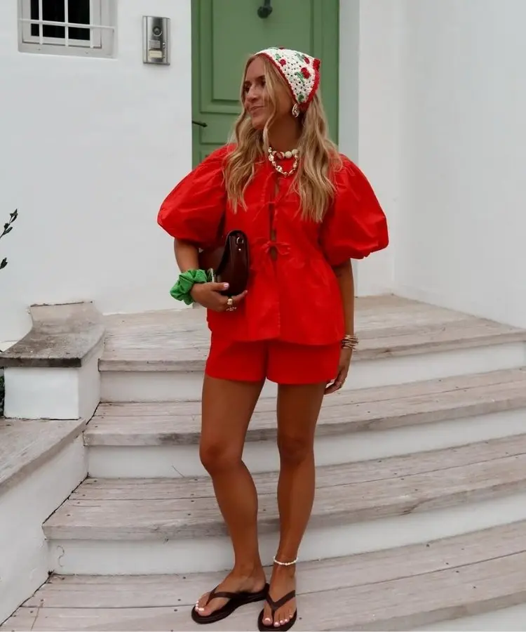 Foto de mulher usando conjunto de blusa e shorts vermelho tomate