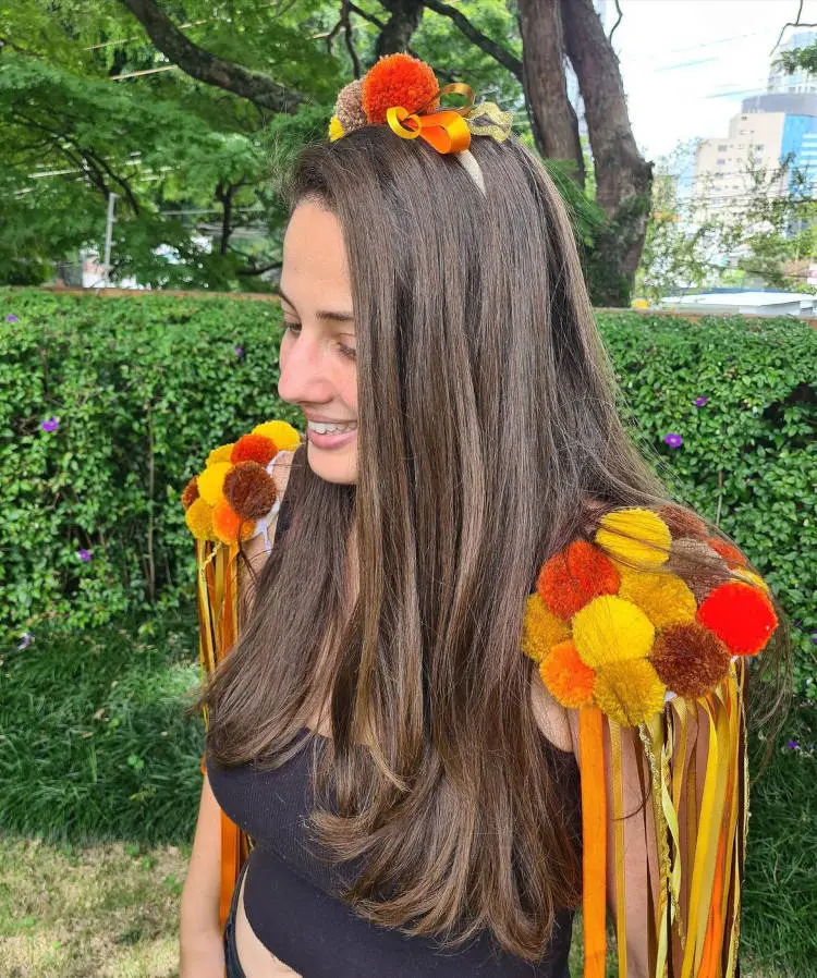 Acessório laranja com pompons.