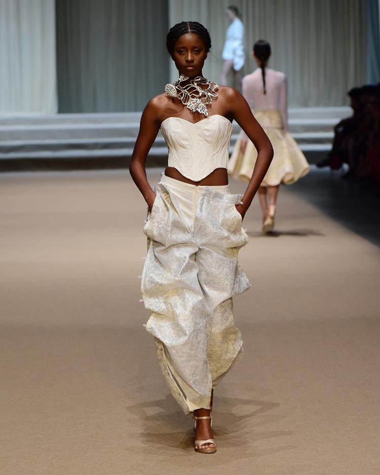 modelo com conjunto de top e calça brancos.