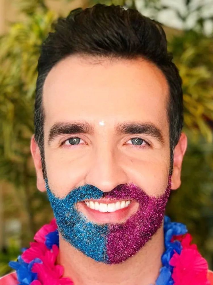 Filipe Almeida com barba de glitter metade azul e metade rosa