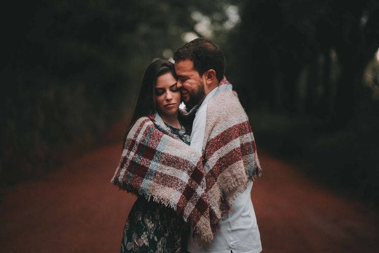 Fotografia casal enrolado na manta