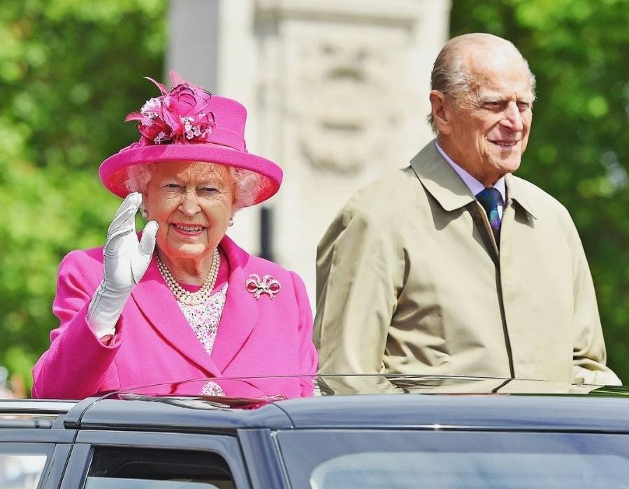 rainha Elizabeth usando terno pink ao lado de seu marido em 2016
