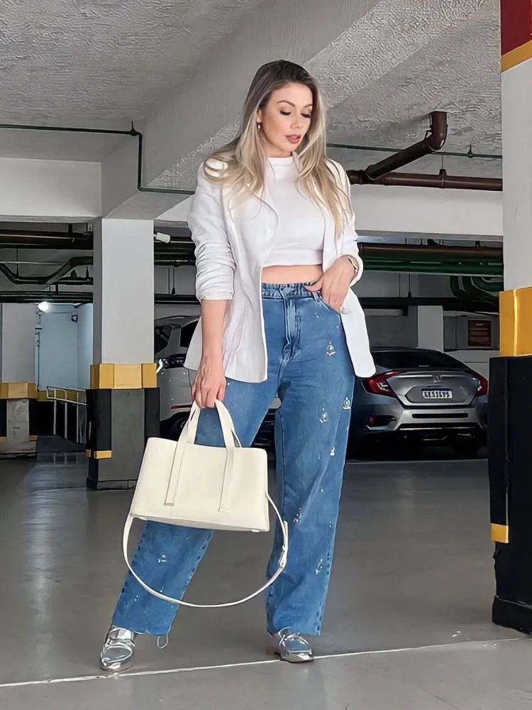 mulher usando blazer branco, calça jeans e mocassim prateado