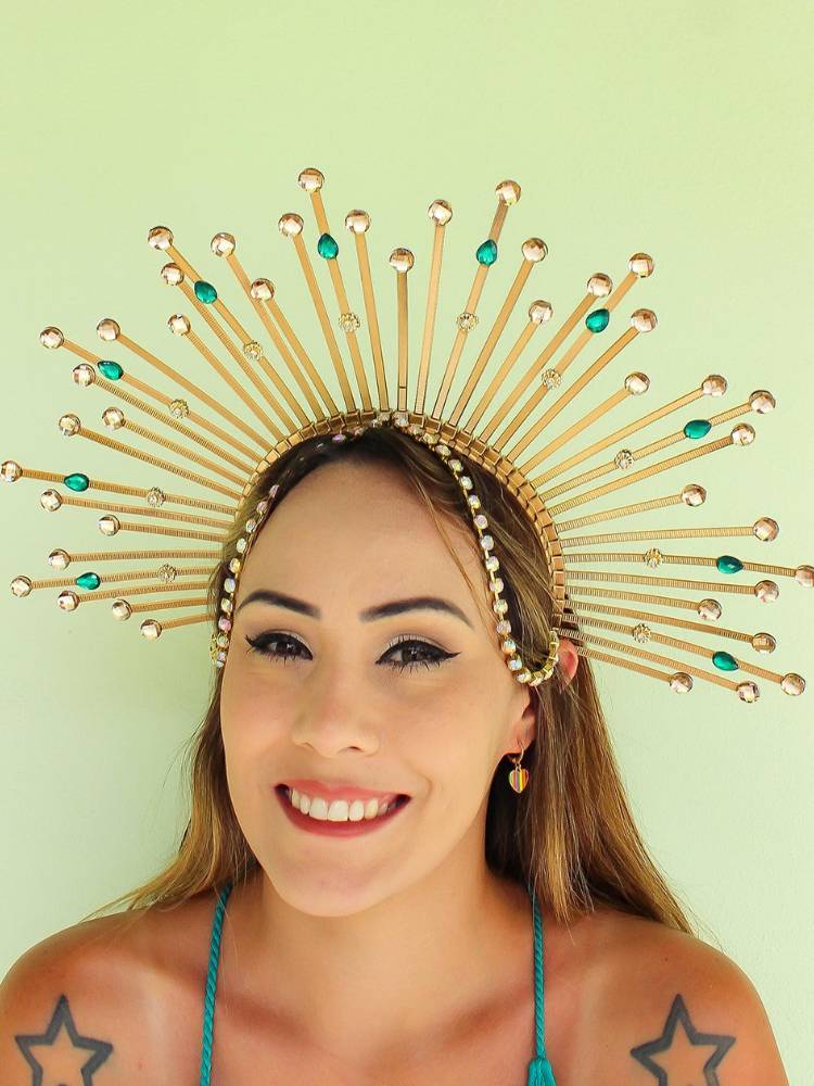 Mulher de pele clara e cabelo loiro usando tiara com imitação de raios solares, com pedras em prata e azul.