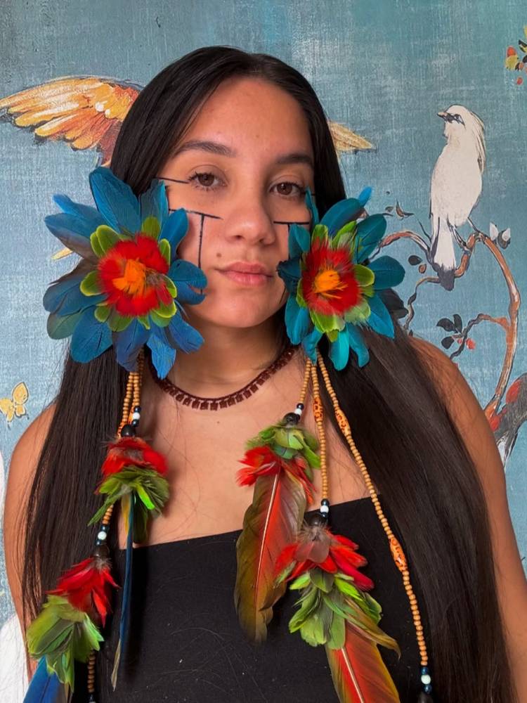 Samela Sateré Mawé usando brincos de flores e roupa preta 