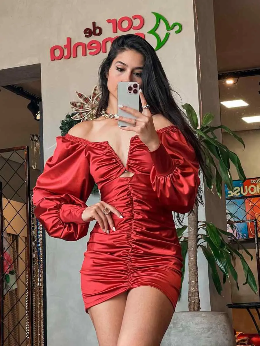 Mulher usando vestido vermelho com manga bufante, drapeado e decote V
