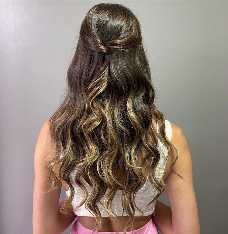 mulher com luzes com cabelo torcido nas laterais e amarrado atrás 