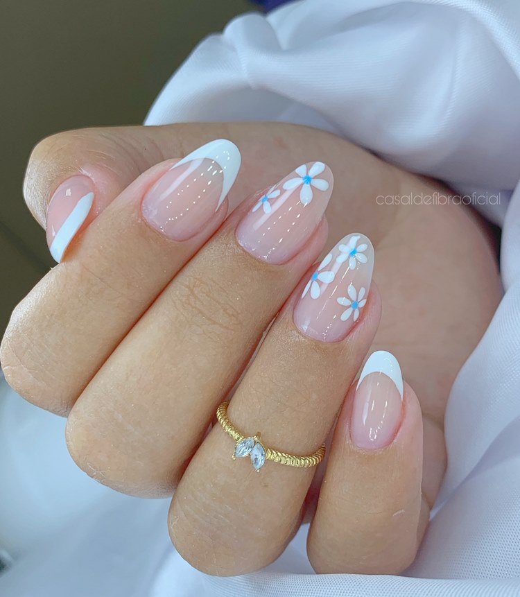 Unhas em gel brancas e azuis com desenhos de florzinhas e francesinha (tamanho: médio. Formato: amendoada) 