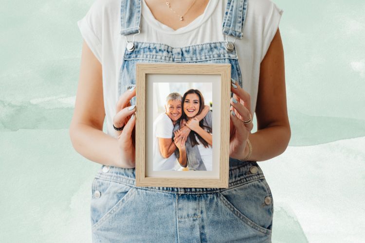 Fundo de aquarela verde com foto de mulher segurando porta-retrato com foto de mãe e filha