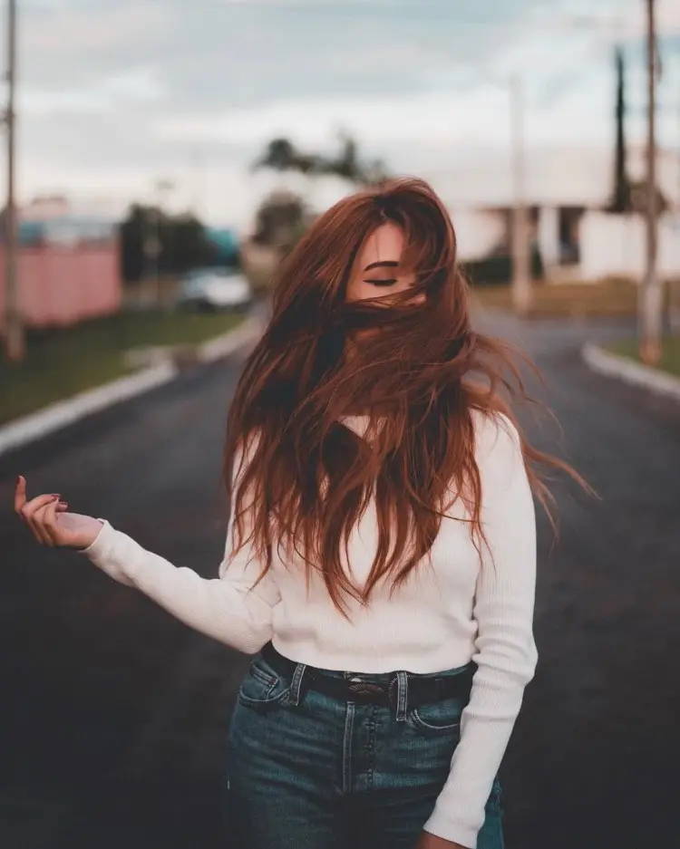 Frase para foto pensativa mulher ruiva usa calça jeans com cinto preto e moletom branco Frase para foto pensativa