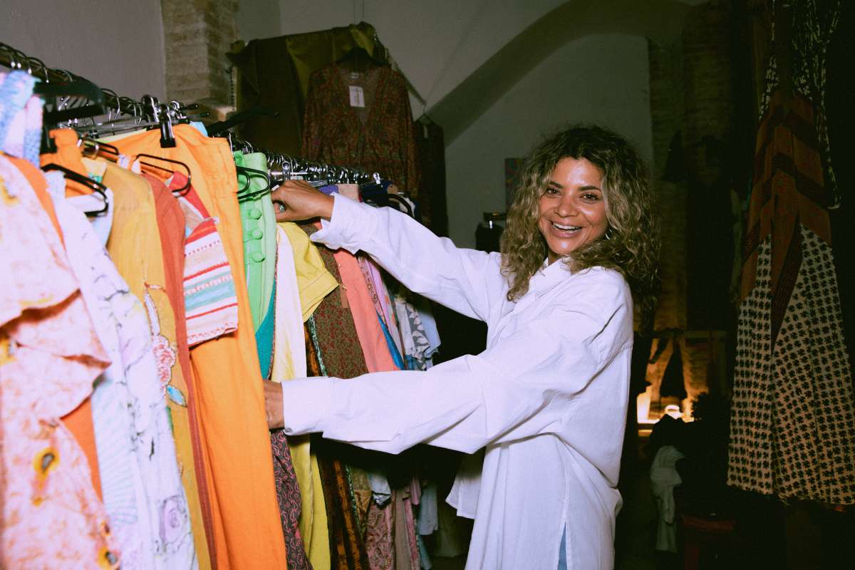 Mulher escolhendo roupas em arara