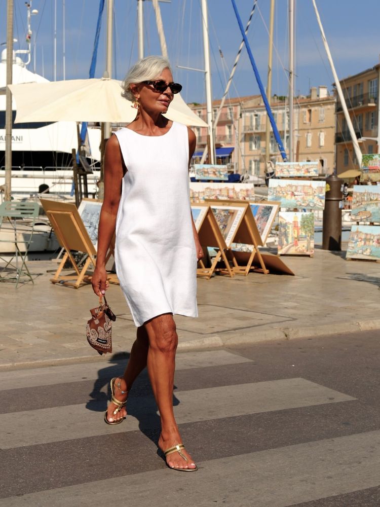Grece Ghanem usando vestido curto branco solto e bolsa com bandana marrom amarrada 
