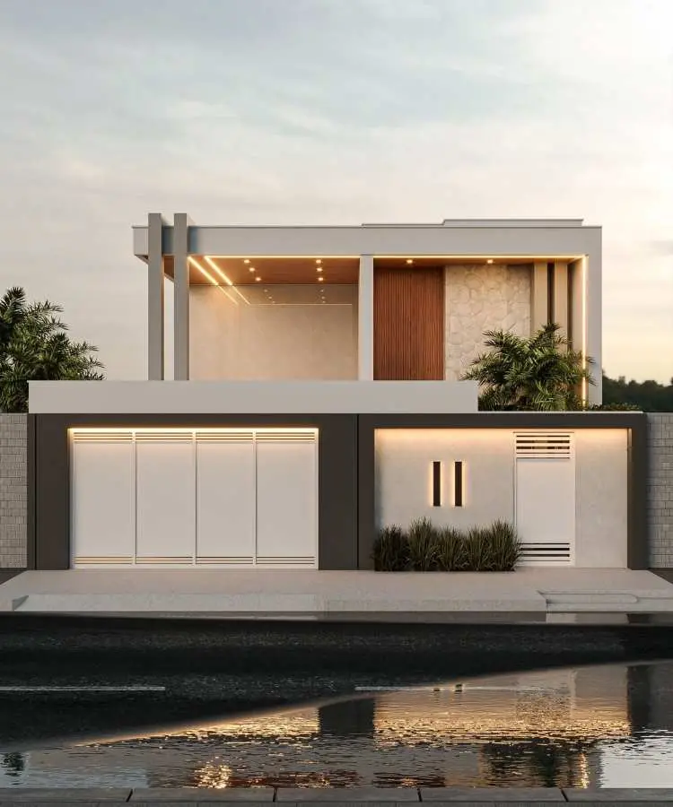 Fachada de casa moderna com dois andares, design minimalista. Piso superior com revestimento amadeirado, paredes em pedra clara e grandes janelas. Piso inferior em branco e cinza, portões iluminados e paisagismo integrado com arbustos. Reflexo na rua molhada ao entardecer.